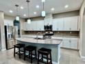 Bright kitchen features a granite island with seating, stainless steel appliances, and ample cabinet space at 251 Silver Maple Rd, Groveland, FL 34736