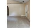 Spacious living room with carpet, neutral walls, and a vaulted ceiling with a white entry door at 1124 Chateau Cir, Minneola, FL 34715