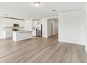 Open-concept kitchen with stainless steel appliances and bright white cabinets at 1489 Sea Glass Rd, Haines City, FL 33844