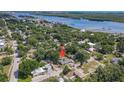 An aerial shot shows the home nestled among trees, conveniently located near a river and a bridge at 111 10Th St, New Smyrna Beach, FL 32168