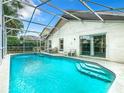 Backyard pool with screened-in enclosure and tiled pool steps at 215 Riggs Cir, Davenport, FL 33897