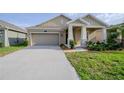Inviting single-story home featuring a two-car garage, covered porch with columns, and a well-kept front lawn at 5315 Amersham Ln, St Cloud, FL 34771