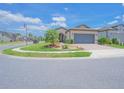 Inviting home with manicured lawn, stone accents, and a paver driveway leading to an attached garage at 745 Asturias Rd, Davenport, FL 33837