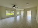Bright living room with large windows, ceiling fan and tiled floors at 5156 City St # 118, Orlando, FL 32839