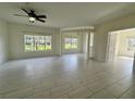 Bright living room with large windows, ceiling fan and tiled floors at 5156 City St # 118, Orlando, FL 32839