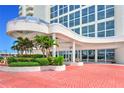 Grand entrance featuring a covered entryway, lush landscaping, and a brick-paved walkway at 2545 S Atlantic Ave # 2107-2108, Daytona Beach Shores, FL 32118