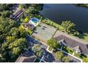 Aerial view of a community featuring a swimming pool, tennis courts, and lush landscaping near the lake at 630 Cranes Way # 105, Altamonte Springs, FL 32701