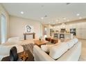 Bright, open-concept living room featuring neutral tones, modern decor, and seamless flow into the kitchen at 737 Alcove Dr, Groveland, FL 34736