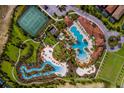 An aerial view showcasing the community pool, lazy river, tennis courts, and manicured landscaping at 4582 Terrasonesta Dr, Davenport, FL 33837