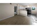 Open-concept living area with neutral carpeting, leading into a modern kitchen with stainless appliances at 122 Club Rd, Sanford, FL 32771