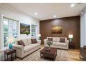 Inviting living room with neutral sofas, stylish wood accent wall, and bright natural light at 1860 Via Contessa, Winter Park, FL 32789