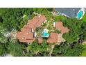 An aerial view of a luxurious estate showcasing a tile roof, lush landscaping and a sparkling swimming pool at 1400 Alabama Dr, Winter Park, FL 32789