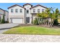 Two-story house with a white exterior, red tile roof, and landscaping at 16829 Bolsena Dr, Montverde, FL 34756