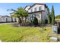 Landscaped yard with palm trees and a gray paved driveway at 16829 Bolsena Dr, Montverde, FL 34756