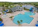Aerial view of the community pool with a waterslide, lounge chairs, and a view of the lake at 17843 Golden Leaf Ln, Orlando, FL 32820
