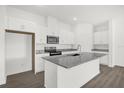 Kitchen island with granite countertop, stainless steel sink, and white cabinets at 8566 Caribbean Pine Way, Lakeland, FL 33809