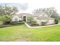 Charming home with a well-manicured lawn, lush landscaping and a brick walkway leading to the entrance at 11602 Graces Way, Clermont, FL 34711