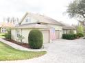 Home featuring a three-car garage, paved driveway and mature landscaping at 11602 Graces Way, Clermont, FL 34711