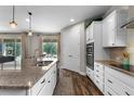 Modern kitchen with granite countertops, stainless steel appliances, and wood-look flooring at 30215 Bretton Loop, Mount Dora, FL 32757