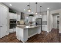 Kitchen featuring white cabinetry, stainless steel appliances, a center island and hardwood floors at 30215 Bretton Loop, Mount Dora, FL 32757