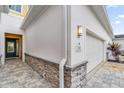 Townhome entry with dark gray door, stone accents, and attached garage at 880 Driving Range Ct, Reunion, FL 34747