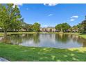 Scenic view of a community pond with a fountain surrounded by lush green lawns and residential townhouses at 2748 Clinton Heights Ct, Oviedo, FL 32765