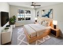 Inviting bedroom with a comfortable bed, ceiling fan, and a large window overlooking the pool and landscaping at 4367 Thornbriar Ln # 108, Orlando, FL 32822