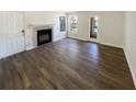 Bright living room features a fireplace, wood floors, and natural light from the windows and exterior door at 4367 Thornbriar Ln # 108, Orlando, FL 32822