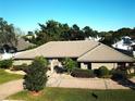 Single-story home with tile roof, landscaped yard, and gated entry at 9227 Cypress Cove Dr, Orlando, FL 32819