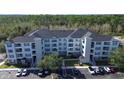 Attractive apartment building featuring light colored siding, a dark roof, and ample parking at 3176 Feltrim Pl # 305, Kissimmee, FL 34747