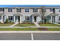 A row of inviting townhouses showcases manicured lawns, sidewalks, and modern architecture at 3221 Douglas Fir Dr, Apopka, FL 32703