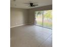 Spacious living room features tiled floors, a ceiling fan, and sliding glass doors to a patio at 2444 Summerfield Way # 1, Kissimmee, FL 34741