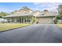 Charming single-story home with a large, inviting front porch and attached two-car garage at 33412 E Lake Joanna Dr, Eustis, FL 32736
