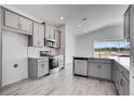 Modern kitchen with stainless steel appliances, gray cabinetry, tile backsplash, and an island with a sink at 4678 Ackee Rd, Kissimmee, FL 34758