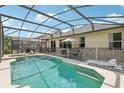 Relaxing pool area with a screened enclosure, patio furniture, and a spa at 273 Willow View Dr, Davenport, FL 33896