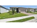 Attractive single-story home boasting a brick driveway and lush green lawn at 3158 Viceroy Ct, Poinciana, FL 34759