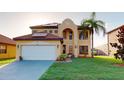 Two-story home with a well-manicured lawn, solar panels and an attached two-car garage at 3044 Camino Real S Dr, Kissimmee, FL 34744