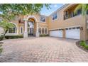 Grand two-story home with a brick driveway and three-car garage at 334 Chadwick Dr, Davenport, FL 33837