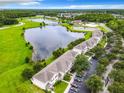 Scenic aerial view of the community featuring a lake, lush landscaping, and ample parking at 2543 Old Kent Cir, Kissimmee, FL 34758