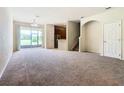 Spacious living room with neutral carpeting, leading to the kitchen and an open-plan design at 2543 Old Kent Cir, Kissimmee, FL 34758