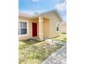 House exterior with red door and landscaping at 328 Chelmsford Ct, Kissimmee, FL 34758