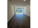 Bright, empty living room with wood floors leading to sliding glass doors and a view of the backyard at 2608 Kinsale Ln, Ormond Beach, FL 32174