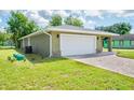 A well-maintained house with a lush green lawn and a brick paver driveway leading to the garage at 2240 Center St, Sanford, FL 32771