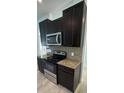 Well-equipped kitchen with stainless steel appliances, dark cabinetry, and elegant granite countertops at 1780 Converse Ct, Deltona, FL 32738