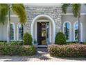 Elegant front entrance with stone archway, arched windows, and lush landscaping at 8300 Ludington Cir, Orlando, FL 32836