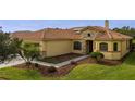 One-story house with tile roof, two-car garage, and lush landscaping at 729 San Raphael St, Kissimmee, FL 34759