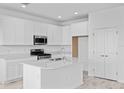Bright, modern kitchen with white cabinets, stainless steel appliances, and center island at 2288 Sirena Ln, Mount Dora, FL 32757