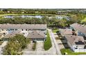 An aerial view of townhomes situated beside a scenic lake, surrounded by lush greenery at 6364 Lake Smith Cir, Windermere, FL 34786