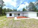 Inviting single-story home with a neatly landscaped yard and an attached two-car garage at 161 Fisher Crse, Ocklawaha, FL 32179