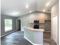 Open-concept kitchen featuring granite countertops, light wood cabinets, and modern black appliances at 161 Fisher Crse, Ocklawaha, FL 32179